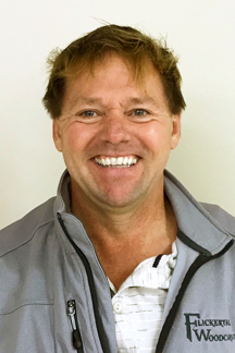 Dale Heglund smiles at the camera while wearing a Flickertail Woodcarvers jacket